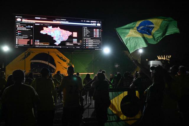 Simpatizantes del senador brasileño de derecha y candidato presidencial del Partido Liberal (PL), Flavio Bolsonaro, observan el conteo de votos durante la segunda vuelta de las elecciones presidenciales de Brasil, en Brasilia, Brasil, el 25 de octubre de 2026. Lula da Silva faces right-wing senator Flavio Bolsonaro in a runoff that will determine whether Brazil remains one of the few leftist nations in the region or joins a regional swing to the right championed by US President Donald Trump, Bolsonaro's ally. (Photo by Evaristo SA / AFP)