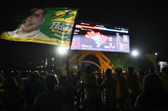 Simpatizantes del senador brasileño de derecha y candidato presidencial del Partido Liberal (PL), Flavio Bolsonaro, observan el conteo de votos durante la segunda vuelta de las elecciones presidenciales de Brasil, en Brasilia, Brasil, el 25 de octubre de 2026. Lula da Silva faces right-wing senator Flavio Bolsonaro in a runoff that will determine whether Brazil remains one of the few leftist nations in the region or joins a regional swing to the right championed by US President Donald Trump, Bolsonaro's ally. (Photo by Evaristo SA / AFP)