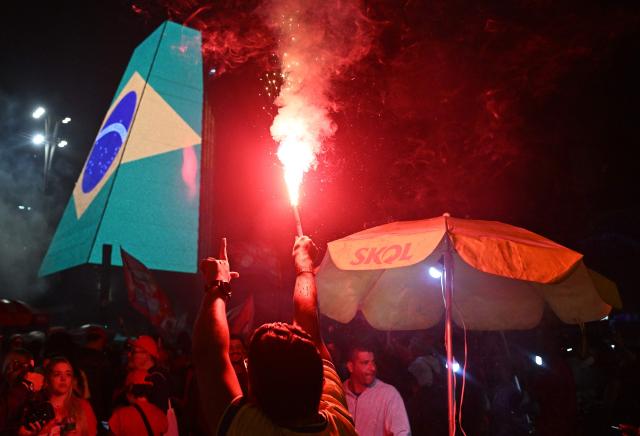 A supporter of Brazil's President and presidential candidate Luiz Inacio Lula da Silva celebrates after the results of the presidential runoff election in Rio de Janeiro, Brazil on October 25, 2026. Lula da Silva pulled off a dramatic comeback on October 25, 2026, as he clinched election victory against right-wing senator Flavio Bolsonaro, who trounced him in the first round. (Photo by Juan BARRETO / AFP)