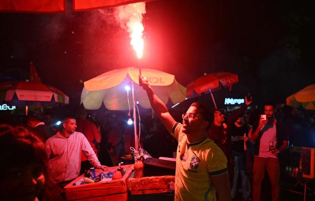 A supporter of Brazil's President and presidential candidate Luiz Inacio Lula da Silva celebrates after the results of the presidential runoff election in Rio de Janeiro, Brazil on October 25, 2026. Lula da Silva pulled off a dramatic comeback on October 25, 2026, as he clinched election victory against right-wing senator Flavio Bolsonaro, who trounced him in the first round. (Photo by Juan BARRETO / AFP)