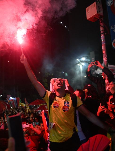 A supporter of Brazil's President and presidential candidate Luiz Inacio Lula da Silva celebrates after the results of the presidential runoff election in Rio de Janeiro, Brazil on October 25, 2026. Lula da Silva pulled off a dramatic comeback on October 25, 2026, as he clinched election victory against right-wing senator Flavio Bolsonaro, who trounced him in the first round. (Photo by Juan BARRETO / AFP)