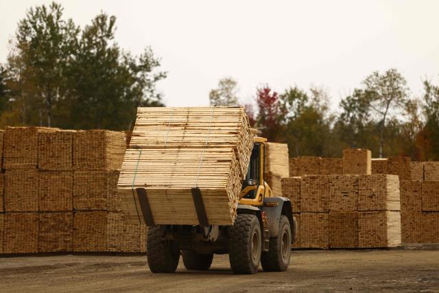 A forklift truck carries softwood lumber at the "Pleasant River Lumber" sawmill in Enfield, Maine, on October 13, 2026. In the heat of US midterm elections, President Donald Trump's tariffs on Canada, and Ottawa's retaliation, have taken center stage in timber-producing Maine, walloped by the economic fallout perhaps more than any other state. Residents in Maine's frontier towns express worry that the tariffs have also triggered a rupture in cross-border relationships built up over decades, and that the intricate community fabric could take years to repair. (Photo by CHARLY TRIBALLEAU / AFP)