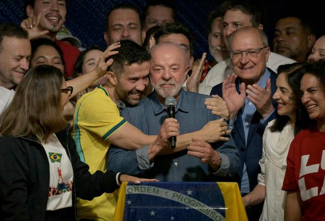 Brazil's President and re-election candidate for the Workers' Party (PT) Luiz Inacio Lula da Silva (C) reacts next to his wife, First Lady Rosangela da Silva (L) and Vice President Geraldo Alckmin (3nd R) after knowing the first results of the presidential runoff election, in Sao Paulo, Brazil, on October 25, 2026. Lula da Silva pulled off a dramatic comeback on October 25, 2026, as he clinched election victory against right-wing senator Flavio Bolsonaro, who trounced him in the first round. (Photo by NELSON ALMEIDA / AFP)