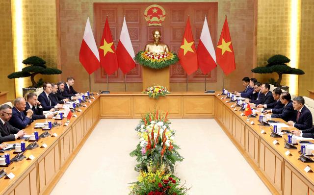 Vietnam's Prime Minister Le Minh Hung (R) and Poland's Prime Minister Donald Tusk (2rd L) attend a meeting at the Government Office in Hanoi on October 26, 2026. (Photo by Quang Nguyen / AFP)