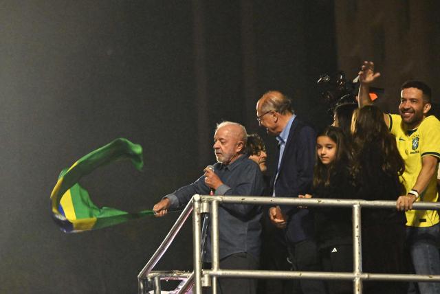 Brazil's President and presidential candidate Luiz Inacio Lula da Silva waves a Brazilian flag as he delivers a speech to supporters after winning the presidential runoff election in Sao Paulo, Brazil, on October 25, 2026. Lula da Silva pulled off a dramatic comeback on October 25, 2026, as he clinched election victory against right-wing senator Flavio Bolsonaro, who trounced him in the first round. (Photo by Juan BARRETO / AFP)
