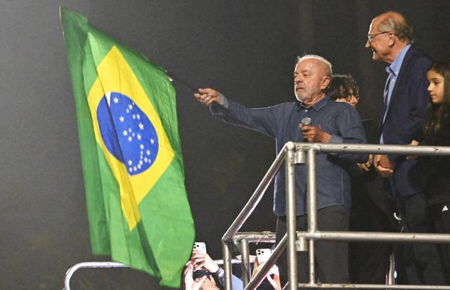 Brazil's President and presidential candidate Luiz Inacio Lula da Silva waves a Brazilian flag as he delivers a speech to supporters after winning the presidential runoff election in Sao Paulo, Brazil, on October 25, 2026. Lula da Silva pulled off a dramatic comeback on October 25, 2026, as he clinched election victory against right-wing senator Flavio Bolsonaro, who trounced him in the first round. (Photo by Juan BARRETO / AFP)