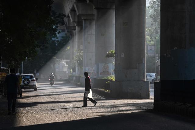 A pedestrian crosses a street in Ahmedabad on October 26, 2026. (Photo by Shammi MEHRA / AFP)