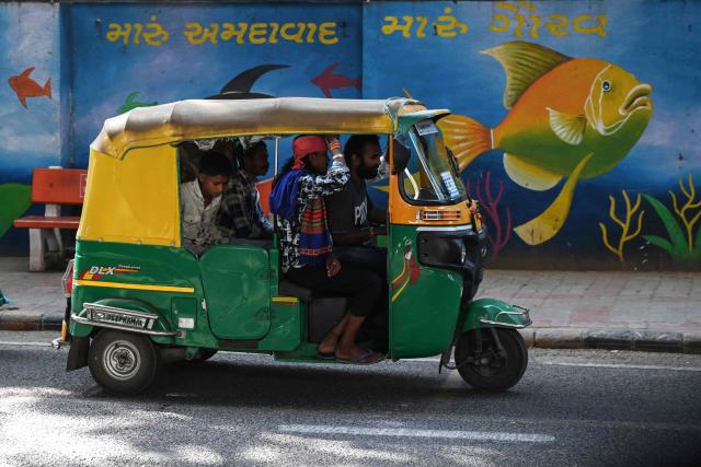 Passengers cram into an auto-rickshaw along a street in Ahmedabad on October 26, 2026. (Photo by Shammi MEHRA / AFP)
