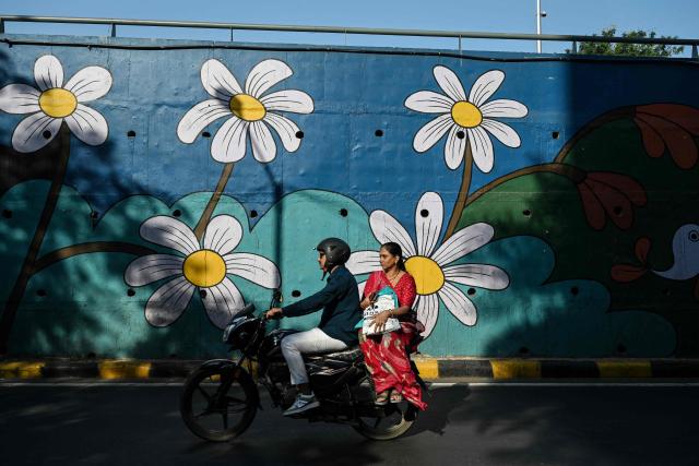 Commuters ride along a street in Ahmedabad on October 26, 2026. (Photo by Shammi MEHRA / AFP)