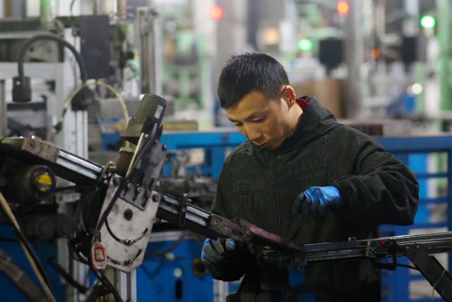 A worker produces magnetic components at the production workshop of Yaorun Technology in the high-tech zone of Qianjiang District in Chongqing, southwest China on October 26, 2026. (Photo by CN-STR / AFP) / China OUT