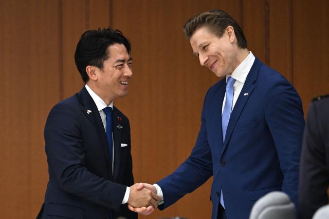 Finland's Defence Minister Antti Hakkanen (R) and Japan's Defence Minister Shinjiro Koizumi shake hands ahead of their meeting at the Ministry of Defence in Tokyo on October 26, 2026. (Photo by Rie KIKUCHI / AFP)