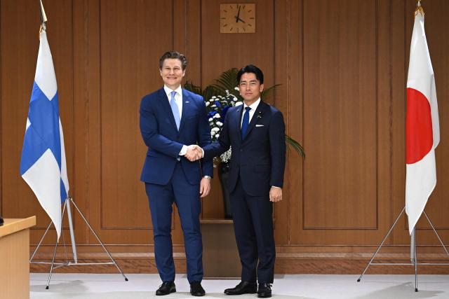 Finland's Defence Minister Antti Hakkanen (R) and Japan's Defence Minister Shinjiro Koizumi shake hands ahead of their meeting at the Ministry of Defence in Tokyo on October 26, 2026. (Photo by Rie KIKUCHI / AFP)