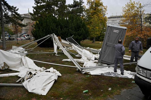 Street cleaning workers clear away the remains of tents and rubbish from a pro-government encampment in a park opposite the Serbian Parliament in Belgrade on October 26, 2026, after crowds celebrating election results entered the site the previous night and dismantled tents that had occupied the area for months, setting them alight along with a number of cars. Serbia's student-led movement declared victory in parliamentary elections on October 25 ending 14 years in power for Aleksandar Vucic's right-wing populist party. The victory in the snap vote comes after nearly two years of anti-government protests sparked by the 2024 collapse of a canopy at Novi Sad railway station that killed 16 people. The disaster has been widely blamed on corruption and triggered some of Serbia's largest protests since the fall of strongman Slobodan Milosevic in 2000. (Photo by Andrej ISAKOVIC / AFP)