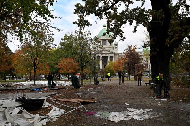 Street cleaning workers clear away the remains of tents and rubbish from a pro-government encampment in a park opposite the Serbian Parliament in Belgrade on October 26, 2026, after crowds celebrating election results entered the site the previous night and dismantled tents that had occupied the area for months, setting them alight along with a number of cars. Serbia's student-led movement declared victory in parliamentary elections on October 25 ending 14 years in power for Aleksandar Vucic's right-wing populist party. The victory in the snap vote comes after nearly two years of anti-government protests sparked by the 2024 collapse of a canopy at Novi Sad railway station that killed 16 people. The disaster has been widely blamed on corruption and triggered some of Serbia's largest protests since the fall of strongman Slobodan Milosevic in 2000. (Photo by Andrej ISAKOVIC / AFP)