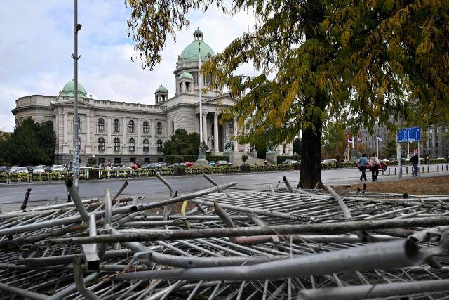 Metal barriers that had surrounded a pro-government encampment are piled up in a park opposite the Serbian Parliament in Belgrade on October 26, 2026, after crowds celebrating election results entered the site the previous night and dismantled tents that had occupied the area for months, setting them alight along with a number of cars. Serbia's student-led movement declared victory in parliamentary elections on October 25 ending 14 years in power for Aleksandar Vucic's right-wing populist party. The victory in the snap vote comes after nearly two years of anti-government protests sparked by the 2024 collapse of a canopy at Novi Sad railway station that killed 16 people. The disaster has been widely blamed on corruption and triggered some of Serbia's largest protests since the fall of strongman Slobodan Milosevic in 2000. (Photo by Andrej ISAKOVIC / AFP)