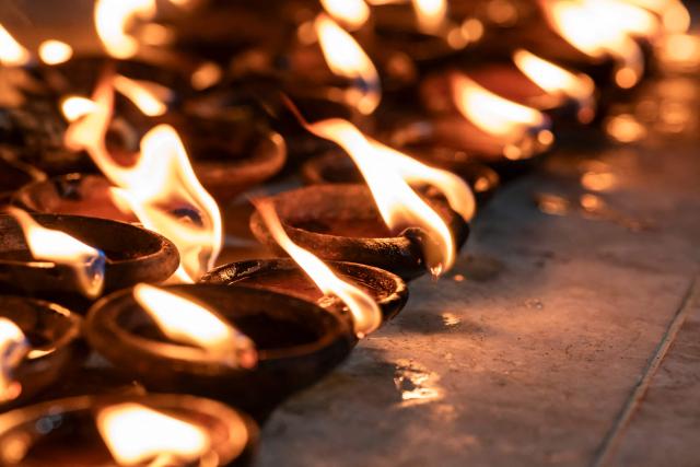 Rows of traditional oil lamps burn at Botahtaung Pagoda on the Full Moon Day of the Thadingyut Festival in Yangon on October 26, 2026. Thousands of Buddhist devotees flocked to pagodas across the city to pray, make merits, and participate in the annual festival of lights marking the end of Buddhist Lent. (Photo by Sai Aung MAIN / AFP)