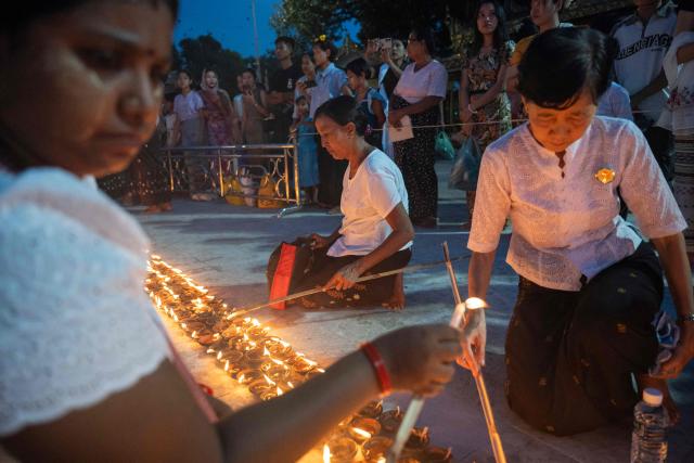 Buddhist devotees light traditional earthenware oil lamps at Botahtaung Pagoda during the Full Moon Day of the Thadingyut Festival in Yangon on October 26, 2026. Thousands of Buddhist devotees flocked to pagodas across the city to pray, make merits, and participate in the annual festival of lights marking the end of Buddhist Lent. (Photo by Sai Aung MAIN / AFP)