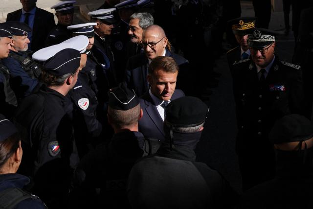 France's President Emmanuel Macron (C) is followed by Interior Minister Laurent Nunez as he meets with police forces in Marseille, southern France on October 26, 2026, during a visit to notice the 'return of republican order' after the violence and looting that punctuated the citizen mobilization of October 17, 2026. Protests by high school students over learning conditions sparked a movement that has since spread nationwide, fuelled by broader anger over the rising cost of living. (Photo by Aurelien Morissard / POOL / AFP)
