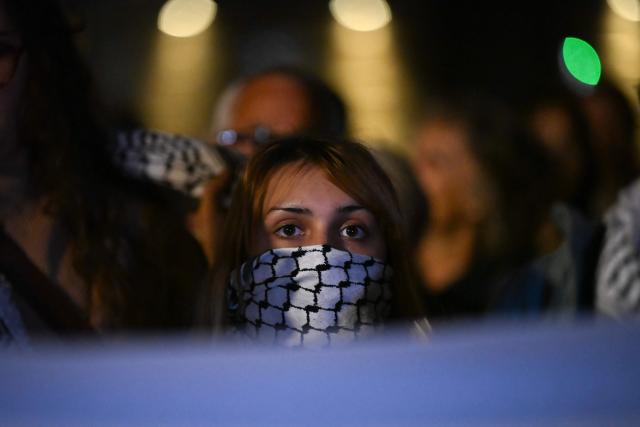 A woman looks on during a tribute to the victims of the Trappes attacks, in the Old Port in Marseille, on October 26, 2026. A man suspected of a gun attack in the Paris suburbs that killed Pengo Bossio Wangi and wounded five other persons has left custody and been placed in a psychiatric unit for observation, French anti-terror prosecutors said on October 25, 2026. The 39-year-old suspect, partly identified as Kevin T., was arrested on October 23, in possession of a submachine gun and tear-gas grenades in his car, shortly after the victims were shot as a vehicle drove through the working-class town of Trappes and neighbouring La Verriere. (Photo by Justine MEDDAH / AFP)