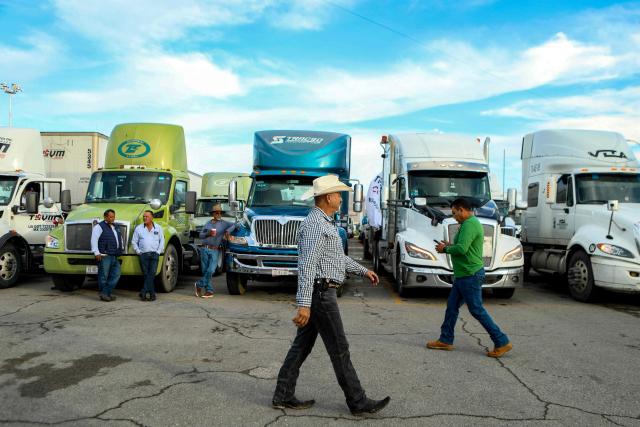 Freight truck drivers remain parked along a road near the US-Mexico border while taking part in a protest dubbed "Mexico No Aguanta Mas" (Mexico Can No Longer Endure), demanding greater security on highways in the border city of Ciudad Juarez, Chihuahua state, Mexico, on October 26, 2026. (Photo by Herika Martinez / AFP)