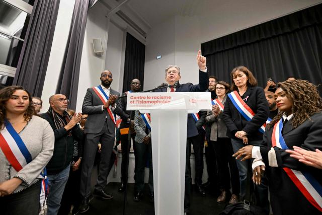 leftist party La France Insoumise (LFI) candidate in France's 2027 presidential election Jean-Luc Melenchon (C), flanked by La Courneuve officials and LFI MPs, addresses a gathering in the town hall of the Paris suburban city of La Courneuve on October 26, 2026, to pay tribute to the victims of the October 23 racist shooting that killed one person and wounded five in Trappes. Marches were held on October 25 in tribute to the man killed in the shooting, Pengo Bossio Wangi, a 26-year-old French national of Congolese origin, and more were planned for today in several French cities, including Paris. (Photo by LOU BENOIST / AFP)