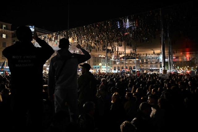 People take part in a tribute to the victims of the Trappes attacks, in the Old Port in Marseille, on October 26, 2026. A man suspected of a gun attack in the Paris suburbs that killed Pengo Bossio Wangi and wounded five other persons has left custody and been placed in a psychiatric unit for observation, French anti-terror prosecutors said on October 25, 2026. The 39-year-old suspect, partly identified as Kevin T., was arrested on October 23, in possession of a submachine gun and tear-gas grenades in his car, shortly after the victims were shot as a vehicle drove through the working-class town of Trappes and neighbouring La Verriere. (Photo by Justine MEDDAH / AFP)