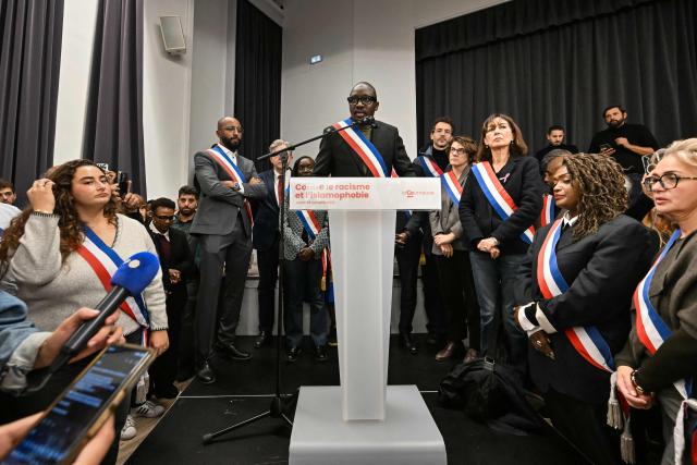 La Courneuve's mayor Aly Diouara, flanked by other city officials and LFI MPs, addresses a gathering in the town hall of the Paris suburban city of La Courneuve on October 26, 2026, to pay tribute to the victims of the October 23 racist shooting that killed one person and wounded five in Trappes. Marches were held on October 25 in tribute to the man killed in the shooting, Pengo Bossio Wangi, a 26-year-old French national of Congolese origin, and more were planned for today in several French cities, including Paris. (Photo by LOU BENOIST / AFP)