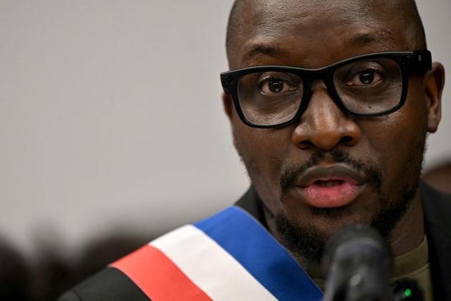 La Courneuve's mayor Aly Diouara addresses a gathering in the town hall of the Paris suburban city of La Courneuve on October 26, 2026, to pay tribute to the victims of the October 23 racist shooting that killed one person and wounded five in Trappes. Marches were held on October 25 in tribute to the man killed in the shooting, Pengo Bossio Wangi, a 26-year-old French national of Congolese origin, and more were planned for today in several French cities, including Paris. (Photo by LOU BENOIST / AFP)