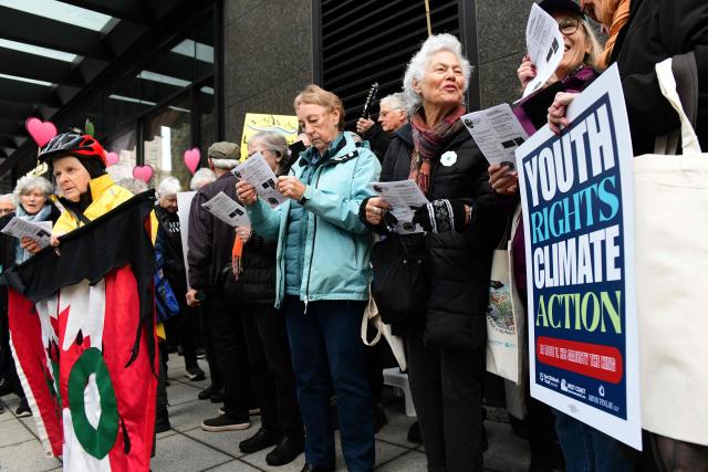 Supporters gather outside the Federal court in Vancouver, British Columbia, on October 26, 2026 to cheer on the plaintiffs of the first youth climate trial in Canada as they enter court on the first day in the La Rose v. His Majesty the King trial. The youth-led federal climate case, La Rose v His Majesty the King, argues federal legislation violates constitutional righs to life, liberty and security by continuing a trajector of greenhouse gas emissions that causes harm. (Photo by Don MacKinnon / AFP)