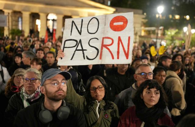 A protester holds a placard reading "No PasRN" referencing "No Pasaran" during a gathering organised by SOS Racisme and other anti-racism organisations at Place de la Bataille-de-Stalingrad in Paris, on October 26, 2026, to denounce the normalisation of racist hatred and pay tribute to the victims of October 23 deadly shooting in Trappes in the Yvelines region. Marches were held on October 25 in tribute to a man killed in the shooting, Pengo Bossio Wangi, a 26-year-old French national of Congolese origin, and more were planned for today in several French cities, including Paris. (Photo by Dimitar DILKOFF / AFP)