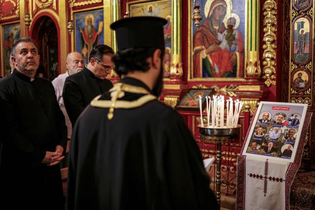 A priest prays during a memorial service at the Greek Orthodox Church of the Transfiguration in the Palestinian city of Ramallah in the Israeli-occupied West Bank, on October 26, 2026, in solidarity with the victims of an attack on the Church of St George in Jordan's village of Hammoud on October 23. On October 23, gunmen stormed the compound of the Greek Orthodox St George's Church in the village of Hammoud in Karak governorate during a funeral procession, killing nine. Karak is home to a significant Christian community in Muslim-majority Jordan, where Christians make up between two and three percent of the population. (Photo by Zain JAAFAR / AFP)