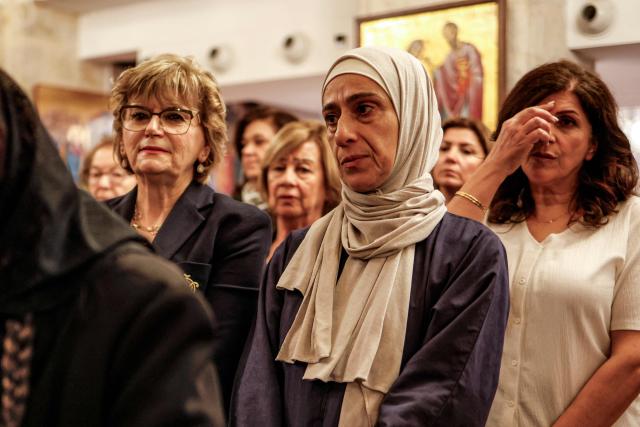 A Palestinian Muslim woman (C) attends a memorial service at the Greek Orthodox Church of the Transfiguration in the Palestinian city of Ramallah in the Israeli-occupied West Bank, on October 26, 2026, in solidarity with the victims of an attack on the Church of St George in Jordan's village of Hammoud on October 23. On October 23, gunmen stormed the compound of the Greek Orthodox St George's Church in the village of Hammoud in Karak governorate during a funeral procession, killing nine. Karak is home to a significant Christian community in Muslim-majority Jordan, where Christians make up between two and three percent of the population. (Photo by Zain JAAFAR / AFP)