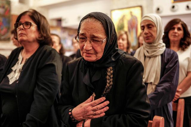 A Palestinian Christian woman reacts during a memorial service at the Greek Orthodox Church of the Transfiguration in the Palestinian city of Ramallah in the Israeli-occupied West Bank, on October 26, 2026, in solidarity with the victims of an attack on the Church of St George in Jordan's village of Hammoud on October 23. On October 23, gunmen stormed the compound of the Greek Orthodox St George's Church in the village of Hammoud in Karak governorate during a funeral procession, killing nine. Karak is home to a significant Christian community in Muslim-majority Jordan, where Christians make up between two and three percent of the population. (Photo by Zain JAAFAR / AFP)