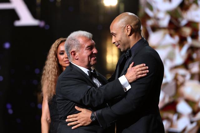 President of FC Barcelona Joan Laporta hugs French former footballer Thierry Henry after receiving the "2026 Ballon d'Or Women's Club of the Year" trophy during the 2026 Ballon d'Or France Football award ceremony at the Palladium Theatre in London on October 26, 2026. (Photo by FRANCK FIFE / AFP)