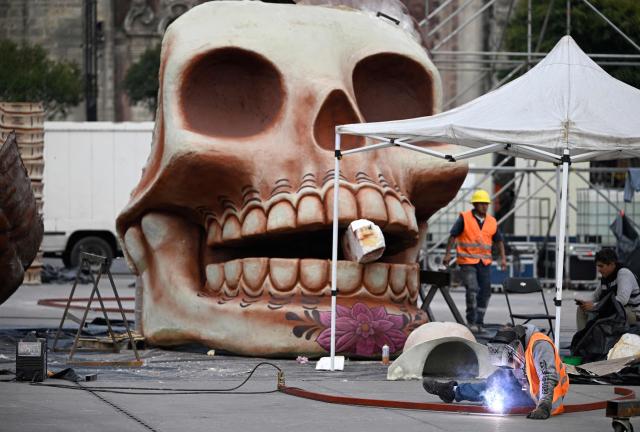 Workers prepare the massive Day of the Dead altar at the Zocalo square in Mexico City on October 26, 2026, ahead of its unveiling on October 29. On November 2, Mexicans celebrate the Day of the Dead, a tradition honoring deceased relatives and loved ones. (Photo by Alfredo ESTRELLA / AFP)