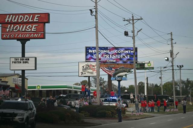 Supporters watch the motorcade of US President Donald Trump drive past in Corinth, Mississippi on October 26, 2026. Trump is travelling to Mississippi to speak at a midterm campaign rally. (Photo by Kent NISHIMURA / AFP)