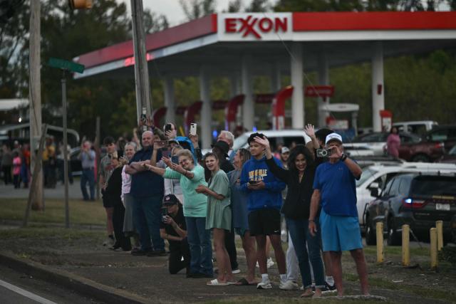 Supporters watch the motorcade of US President Donald Trump drive past in Corinth, Mississippi, on October 26, 2026. Trump is travelling to Mississippi to speak at a midterm campaign rally. (Photo by Kent NISHIMURA / AFP)