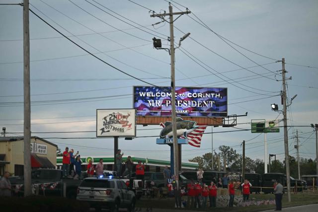 Supporters watch the motorcade of US President Donald Trump drive past in Corinth, Mississippi, on October 26, 2026. Trump is travelling to Mississippi to speak at a midterm campaign rally. (Photo by Kent NISHIMURA / AFP)