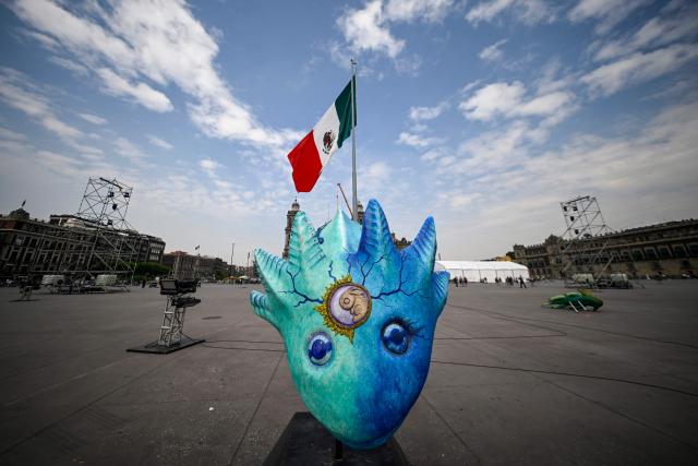 An axolotl figure is seen at the massive Day of the Dead altar being prepared at the Zocalo square in Mexico City on October 26, 2026, ahead of its unveiling on October 29. On November 2, Mexicans celebrate the Day of the Dead, a tradition honoring deceased relatives and loved ones. (Photo by Alfredo ESTRELLA / AFP)