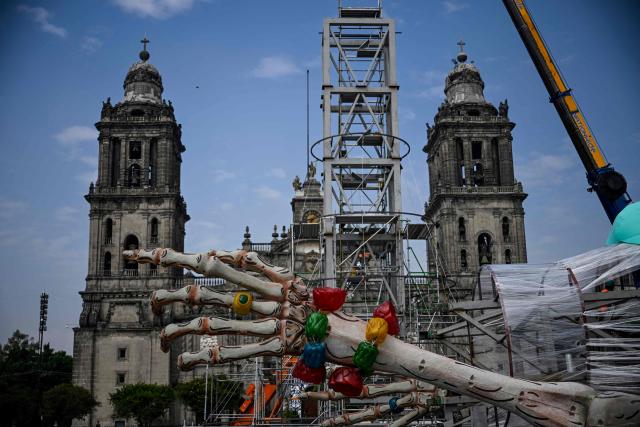 Workers prepare the massive Day of the Dead altar at the Zocalo square in Mexico City on October 26, 2026, ahead of its unveiling on October 29. On November 2, Mexicans celebrate the Day of the Dead, a tradition honoring deceased relatives and loved ones. (Photo by Alfredo ESTRELLA / AFP)