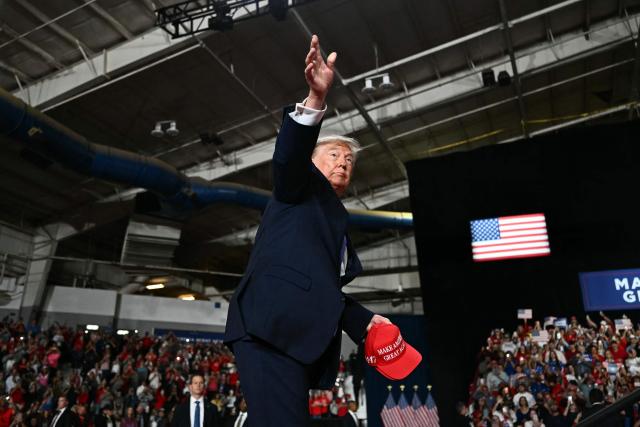 US President Donald Trump throws hats into the crowd before speaking at a midterm campaign rally at Crossroads Arena in Corinth, Mississippi on October 26, 2026. President Trump is holding the campaign rally to support the re-election campaign of US Senatory Cindy Hyde-Smith (R-MS). (Photo by Kent NISHIMURA / AFP)
