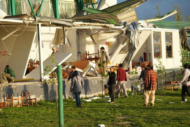 Residents stand near a house damaged by a tornado in Requinoa, O'Higgins Region, Chile on October 26, 2026. Severe weather affected central Chile as strong winds and unstable atmospheric conditions impacted several communities in the region. (Photo by PABLO MARDONES / AFP)