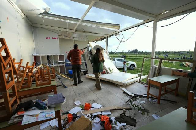 Residents inspect a house damaged by a tornado in Requinoa, O'Higgins Region, Chile on October 26, 2026. Severe weather affected central Chile as strong winds and unstable atmospheric conditions impacted several communities in the region. (Photo by PABLO MARDONES / AFP)