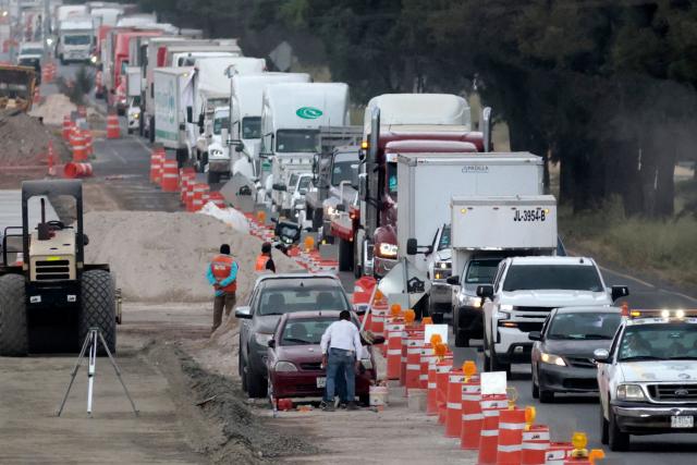 Freight trucks drive along a federal highway while taking part in a protest dubbed "Mexico No Aguanta Mas" (Mexico Can No Longer Endure), demanding greater security on highways in El Salto, Jalisco state, Mexico, on October 26, 2026. (Photo by ULISES RUIZ / AFP)