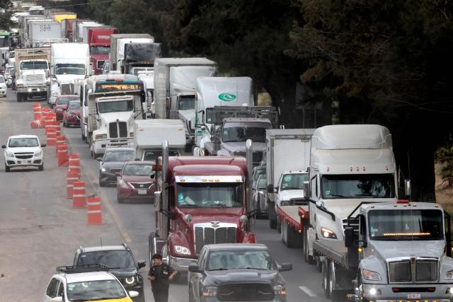 Freight trucks drive along a federal highway while taking part in a protest dubbed "Mexico No Aguanta Mas" (Mexico Can No Longer Endure), demanding greater security on highways in El Salto, Jalisco state, Mexico, on October 26, 2026. (Photo by ULISES RUIZ / AFP)
