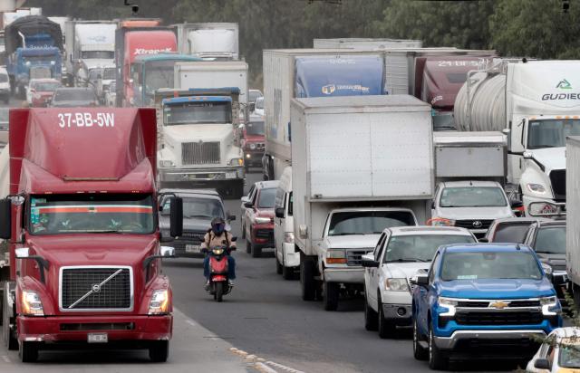 Freight trucks drive along a federal highway while taking part in a protest dubbed "Mexico No Aguanta Mas" (Mexico Can No Longer Endure), demanding greater security on highways in El Salto, Jalisco state, Mexico, on October 26, 2026. (Photo by ULISES RUIZ / AFP)