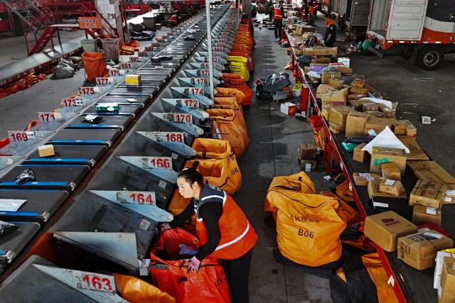 Workers sort parcels at an online shopping distribution centre in Lianyungang, in eastern China's Jiangsu province, on October 27, 2026. (Photo by CN-STR / AFP) / China OUT