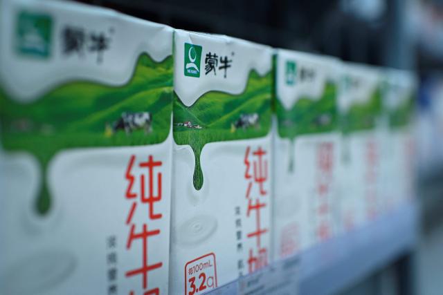 (FILES) Mengniu milk products are seen on a shelf at a store in Beijing on June 24, 2019. Kylian Mbappe was dropped on October 27, 2026 by two major brands in China after a video circulated online in which the French football star apparently joked about former leader Mao Zedong. Mengniu, China's largest dairy producer, cut ties with the Real Madrid and France forward. (Photo by WANG Zhao / AFP)