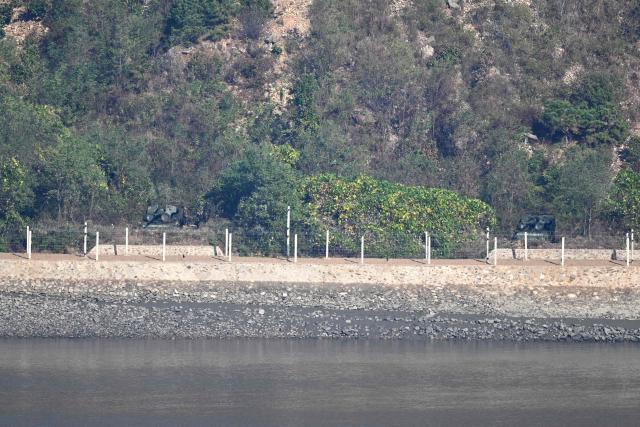 Two of what appear to be North Korean self-propelled howitzers on the North side of the Demilitarised Zone (DMZ) dividing the two Koreas, are seen from a South Korean observation deck at Aegibong Peace Ecopark in Gimpo on October 27, 2026. (Photo by Jung Yeon-je / AFP)