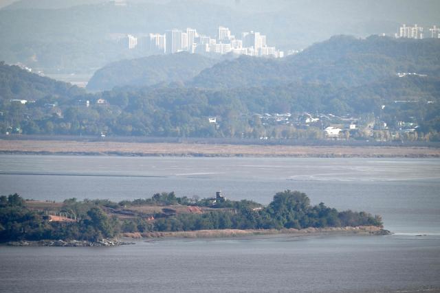 A North Korean guard post and military fences (bottom) on the North side of the Demilitarised Zone (DMZ) dividing the two Koreas, and the South Korean territory (top) are seen from a South Korean observation deck at Aegibong Peace Ecopark in Gimpo on October 27, 2026. (Photo by Jung Yeon-je / AFP)